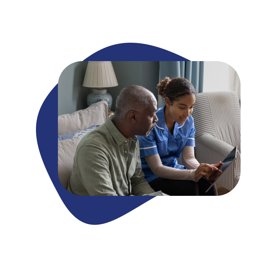 Older male patient with nurse in hotel room discussing in-room medical services using a laptop in Orlando, Florida.
