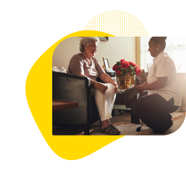 Nurse discussing healthcare with elderly patient in a room, offering telemedicine and in-room medical services
