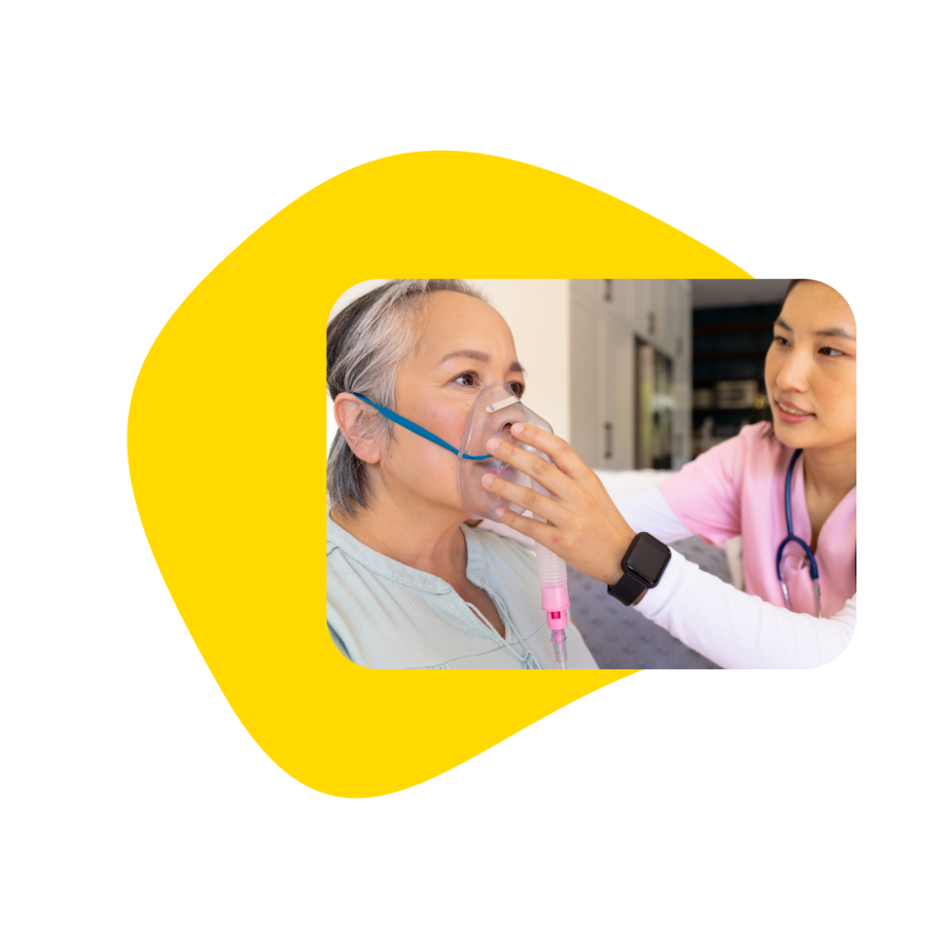 Nurse administering oxygen to a patient in a hotel room during an in-room medical visit.